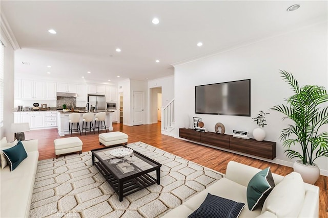 41 Somerton, Irvine, CA 92620 - living area featuring light wood-style flooring, crown molding, recessed lighting, and stairway