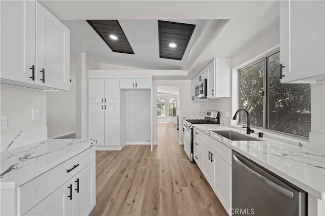43906 Broadwater Ave, Lancaster, CA 93535 - kitchen with appliances with stainless steel finishes, light stone countertops, light wood-style flooring, white cabinetry, and recessed lighting