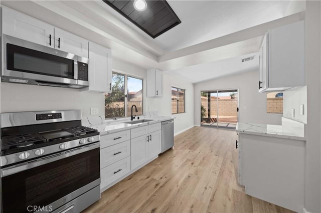 43906 Broadwater Ave, Lancaster, CA 93535 - kitchen with appliances with stainless steel finishes, white cabinetry, light stone countertops, light wood-style floors, and vaulted ceiling