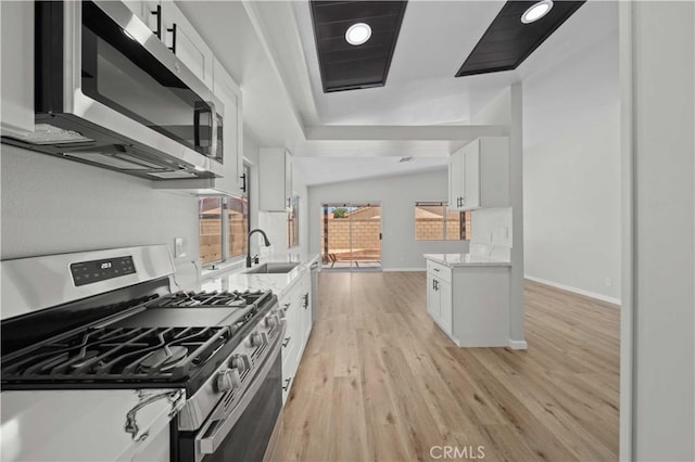 43906 Broadwater Ave, Lancaster, CA 93535 - kitchen featuring stainless steel appliances, white cabinetry, light wood-type flooring, and light stone counters