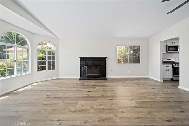 43906 Broadwater Ave, Lancaster, CA 93535 - unfurnished living room with vaulted ceiling, wood finished floors, a ceiling fan, and a brick fireplace