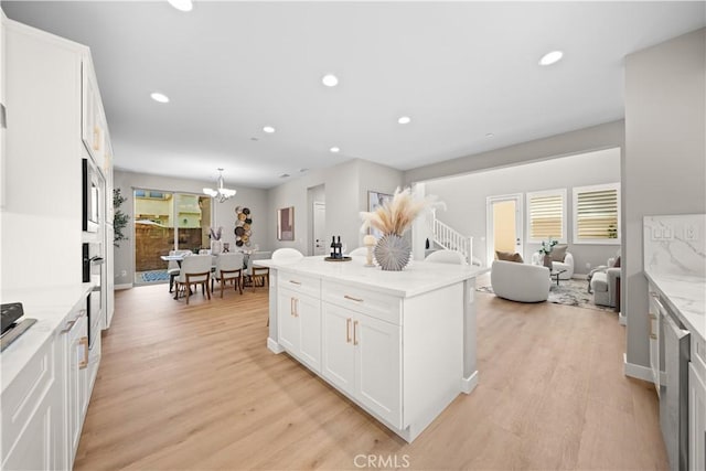 22 Lomada St, Rancho Mission Viejo, CA 92694 - kitchen featuring light wood-style floors, white cabinets, recessed lighting, open floor plan, and a chandelier