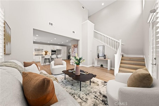 22 Lomada St, Rancho Mission Viejo, CA 92694 - living room featuring a high ceiling, stairway, light wood-type flooring, and recessed lighting