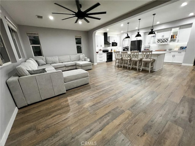 5834 Gem Ct, Lancaster, CA 93536 - living room featuring wood finished floors, ceiling fan, recessed lighting, and arched walkways