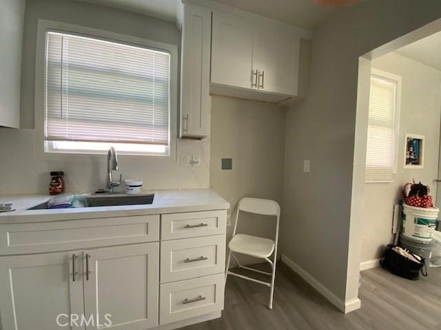 840 W 27th St, San Bernardino, CA 92405 - kitchen featuring dark wood-type flooring, light countertops, and white cabinets