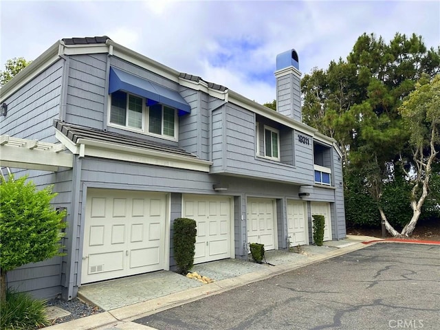19311 Sunray Ln Unit 104, Huntington Beach, CA 92648 - view of side of property featuring a chimney and a garage