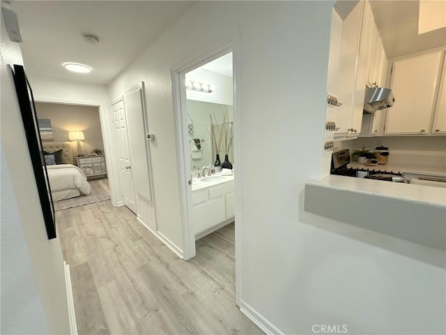 19311 Sunray Ln Unit 104, Huntington Beach, CA 92648 - hallway with light wood-style flooring and a sink