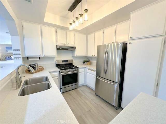19311 Sunray Ln Unit 104, Huntington Beach, CA 92648 - kitchen featuring stainless steel appliances, under cabinet range hood, light wood-style flooring, light countertops, and white cabinetry
