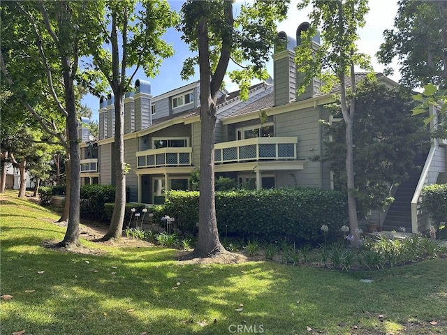 19311 Sunray Ln Unit 104, Huntington Beach, CA 92648 - rear view of house featuring a chimney and a lawn