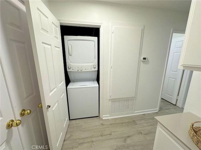 19311 Sunray Ln Unit 104, Huntington Beach, CA 92648 - washroom with stacked washing machine and dryer and light wood-style flooring