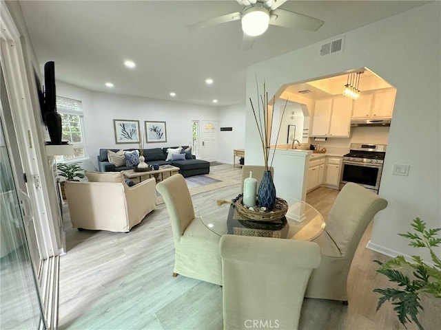 19311 Sunray Ln Unit 104, Huntington Beach, CA 92648 - dining space featuring light wood-style floors, ceiling fan, recessed lighting, and arched walkways