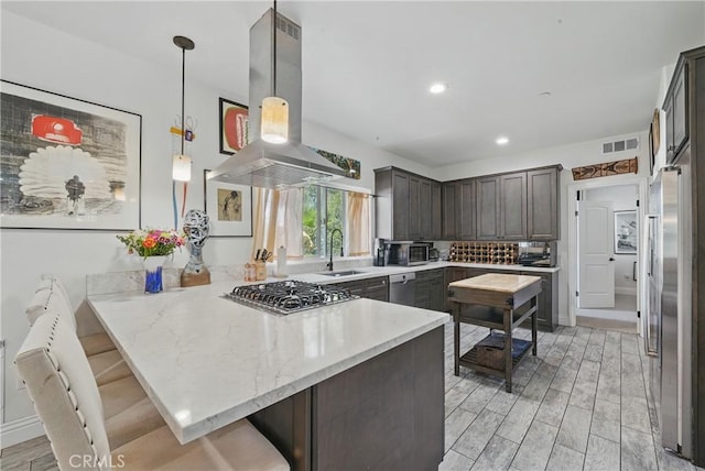 1909 Arroyo Ave, Oceanside, CA 92056 - kitchen featuring stainless steel appliances, island range hood, a peninsula, dark brown cabinetry, and light wood-style flooring