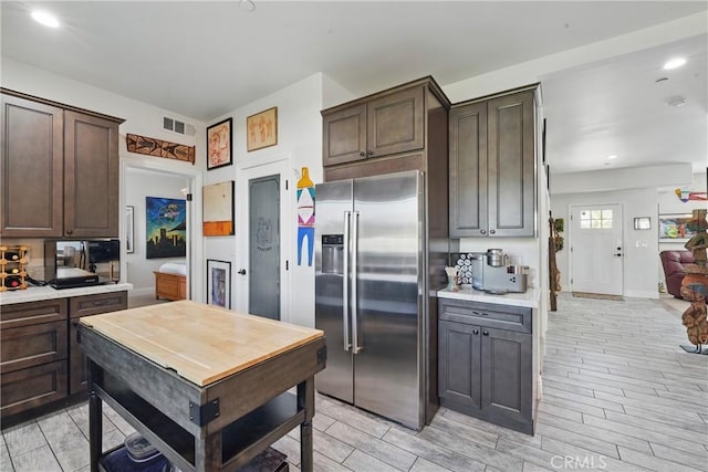 1909 Arroyo Ave, Oceanside, CA 92056 - kitchen featuring high end refrigerator, dark brown cabinets, light countertops, light wood finished floors, and recessed lighting