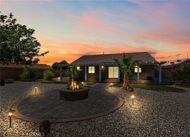 27239 Peach Tree Ln, Helendale, CA 92342 - back of property at dusk with an outdoor fire pit and a patio