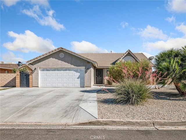 27239 Peach Tree Ln, Helendale, CA 92342 - single story home featuring an attached garage, concrete driveway, a tiled roof, and stucco siding