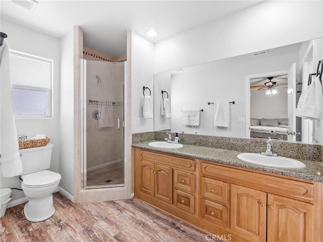 27239 Peach Tree Ln, Helendale, CA 92342 - bathroom with connected bathroom, a shower stall, double vanity, a ceiling fan, and wood finished floors