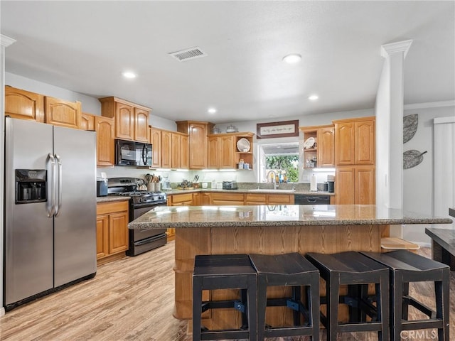 27239 Peach Tree Ln, Helendale, CA 92342 - kitchen with black appliances, open shelves, a kitchen breakfast bar, light wood finished floors, and light stone countertops