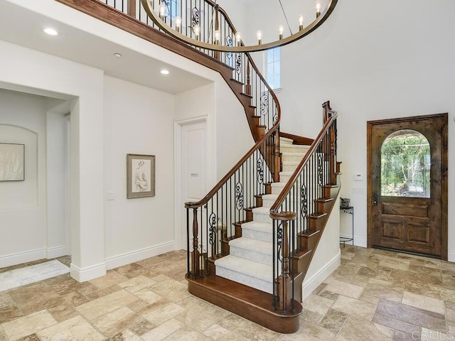 32110 Dos Ninas, Bonsall, CA 92003 - entryway featuring stone tile floors, stairway, a high ceiling, a chandelier, and recessed lighting