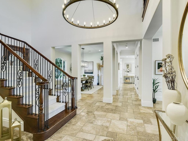 32110 Dos Ninas, Bonsall, CA 92003 - foyer entrance featuring a chandelier, stone tile floors, a towering ceiling, and stairway
