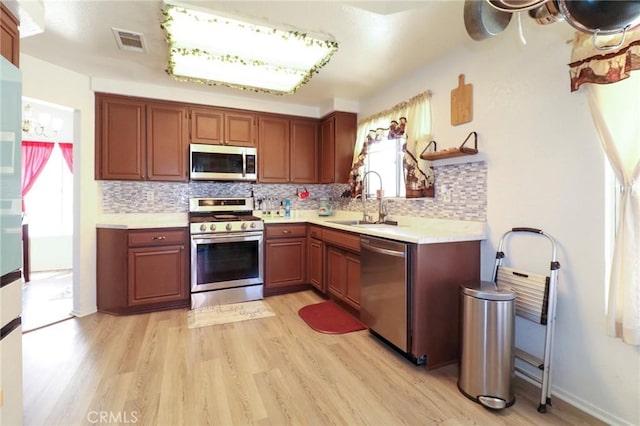 4242 Trenton Ave, Palmdale, CA 93552 - kitchen featuring stainless steel appliances, light wood finished floors, and decorative backsplash