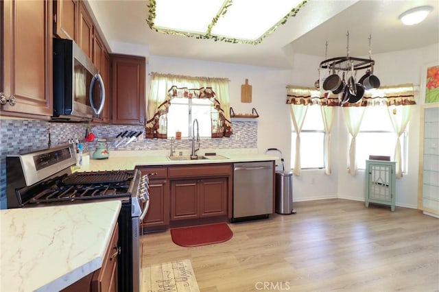 4242 Trenton Ave, Palmdale, CA 93552 - kitchen featuring appliances with stainless steel finishes, a chandelier, light wood finished floors, and tasteful backsplash