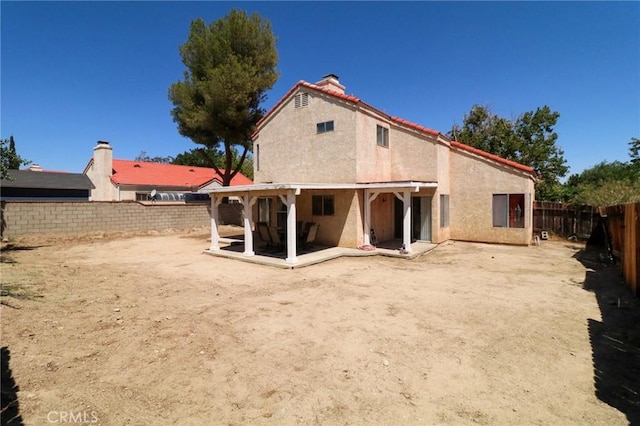 4242 Trenton Ave, Palmdale, CA 93552 - back of house with stucco siding, a fenced backyard, a patio area, and a chimney