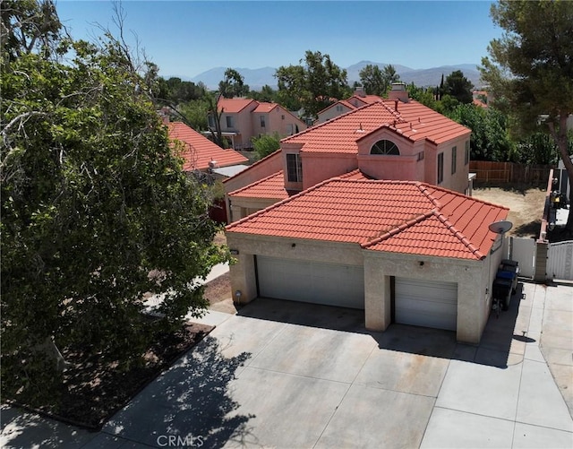 4242 Trenton Ave, Palmdale, CA 93552 - mediterranean / spanish-style home featuring stucco siding, a mountain view, a garage, concrete driveway, and a tile roof
