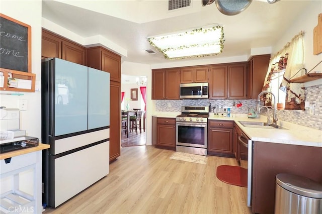4242 Trenton Ave, Palmdale, CA 93552 - kitchen featuring stainless steel appliances, light countertops, decorative backsplash, and light wood finished floors