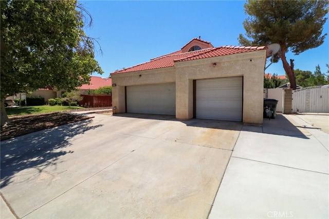 4242 Trenton Ave, Palmdale, CA 93552 - view of front of property featuring stucco siding, a tile roof, a gate, driveway, and a garage