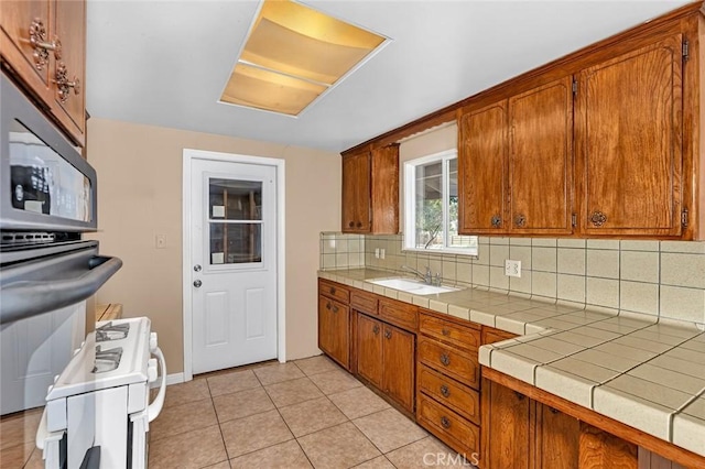 45660 Shain Ave, Dos Palos, CA 93620 - kitchen featuring backsplash, brown cabinets, and electric stove