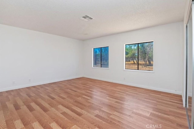 23405 Ramona Ave, Apple Valley, CA 92307 - empty room featuring light wood-style floors and a textured ceiling