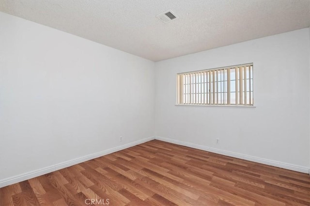23405 Ramona Ave, Apple Valley, CA 92307 - unfurnished room with light wood-style flooring and a textured ceiling