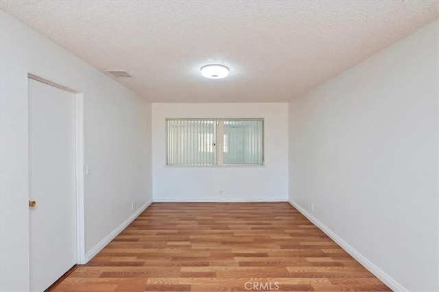 23405 Ramona Ave, Apple Valley, CA 92307 - empty room with a textured ceiling and light wood-style floors