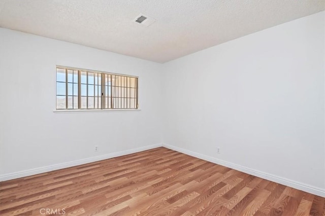 23405 Ramona Ave, Apple Valley, CA 92307 - empty room with light wood-style flooring and a textured ceiling