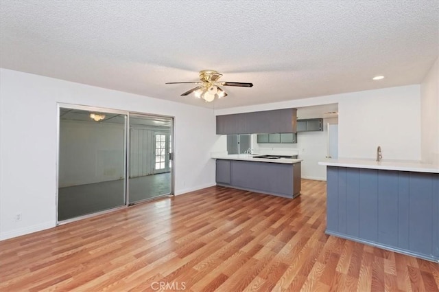 23405 Ramona Ave, Apple Valley, CA 92307 - unfurnished living room with a textured ceiling, light wood-style flooring, and ceiling fan