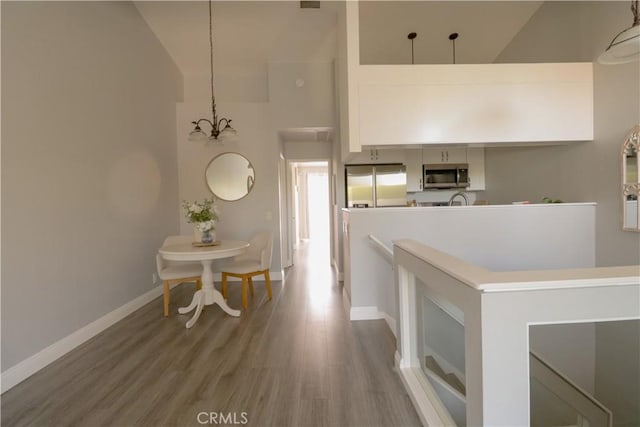 14005 Arthur Ave Unit 21, Paramount, CA 90723 - hall featuring wood finished floors, high vaulted ceiling, and a chandelier