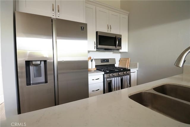 14005 Arthur Ave Unit 21, Paramount, CA 90723 - kitchen featuring appliances with stainless steel finishes, white cabinetry, and light stone countertops