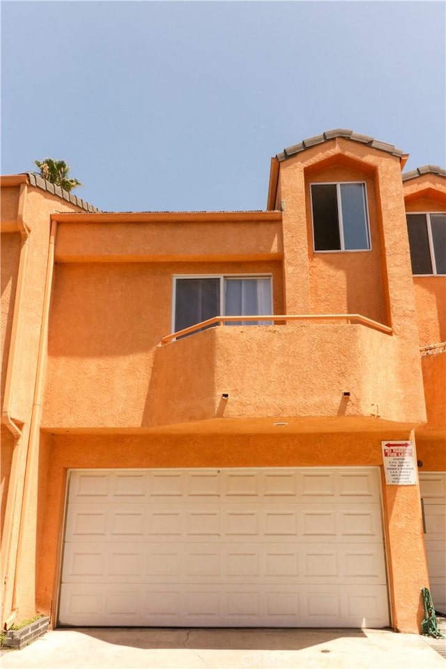 14005 Arthur Ave Unit 21, Paramount, CA 90723 - view of front of home featuring an attached garage, stucco siding, and concrete driveway