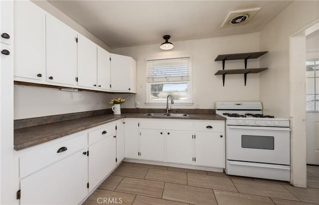 35354 Ave A, Yucaipa, CA 92399 - kitchen with white range with gas cooktop, dark countertops, white cabinets, and open shelves