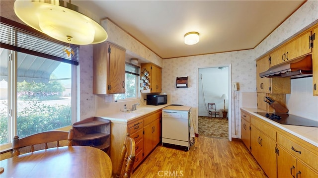 125 Hilton St, Madera, CA 93637 - kitchen with black appliances, wallpapered walls, light wood finished floors, under cabinet range hood, and tile countertops