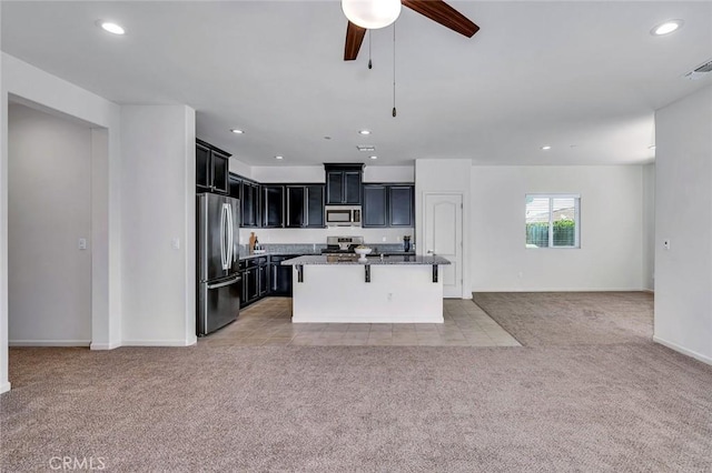 860 Fritz Dr, Los Banos, CA 93635 - kitchen with appliances with stainless steel finishes, open floor plan, light carpet, dark cabinetry, and recessed lighting