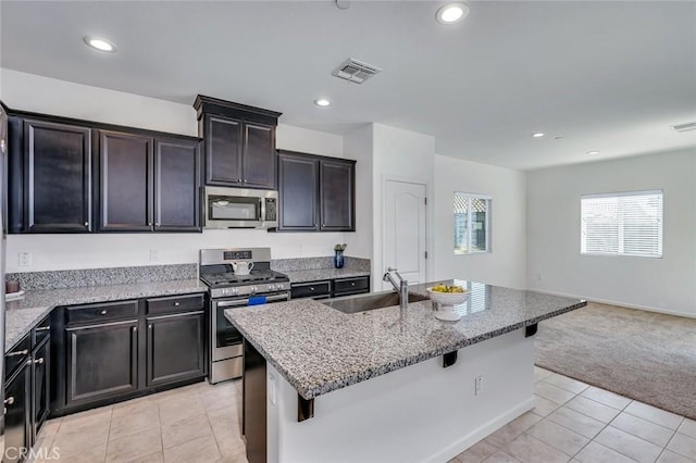 860 Fritz Dr, Los Banos, CA 93635 - kitchen featuring stainless steel appliances, light carpet, light stone counters, open floor plan, and recessed lighting