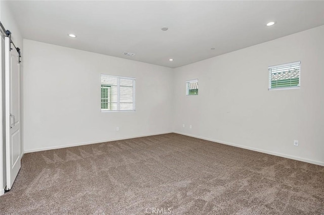 860 Fritz Dr, Los Banos, CA 93635 - unfurnished bedroom with a barn door, carpet, multiple windows, and recessed lighting