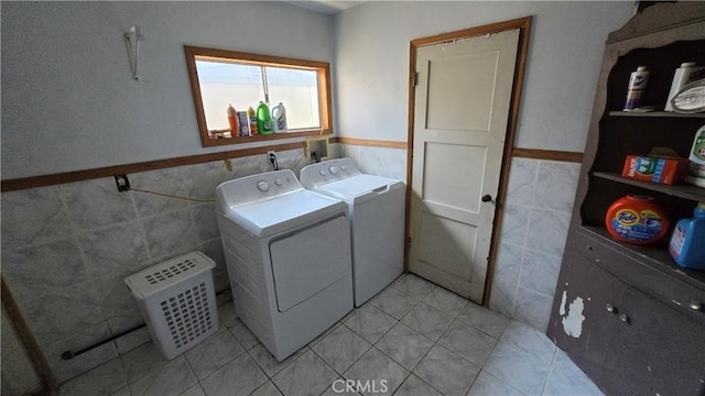 7044 Pellet St, Downey, CA 90241 - laundry room with tile walls, washing machine and clothes dryer, a wainscoted wall, and light tile patterned floors