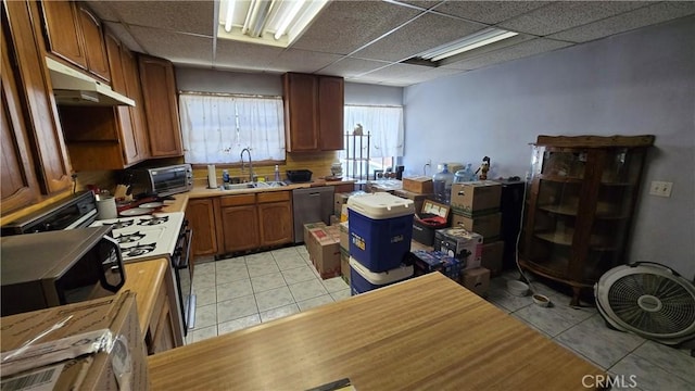 7044 Pellet St, Downey, CA 90241 - kitchen featuring light tile patterned flooring, dishwasher, a paneled ceiling, light countertops, and under cabinet range hood
