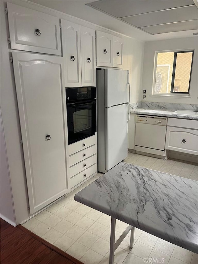 834UnitP Ronda Mendoza, Laguna Woods, CA 92637 - kitchen with white appliances, white cabinetry, light wood finished floors, and light stone counters