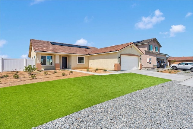 10132 Kemper Ave, Adelanto, CA 92301 - view of front facade with stucco siding, concrete driveway, roof mounted solar panels, an attached garage, and a tile roof