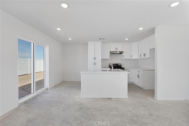 10132 Kemper Ave, Adelanto, CA 92301 - kitchen featuring under cabinet range hood, white cabinetry, unfinished concrete floors, recessed lighting, and light countertops
