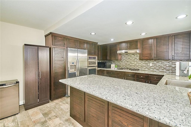 19 Las Cruces, Irvine, CA 92614 - kitchen featuring stainless steel appliances, under cabinet range hood, recessed lighting, light stone counters, and backsplash