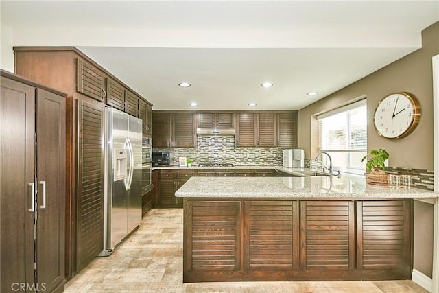 19 Las Cruces, Irvine, CA 92614 - kitchen featuring stainless steel appliances, a peninsula, recessed lighting, backsplash, and light stone counters
